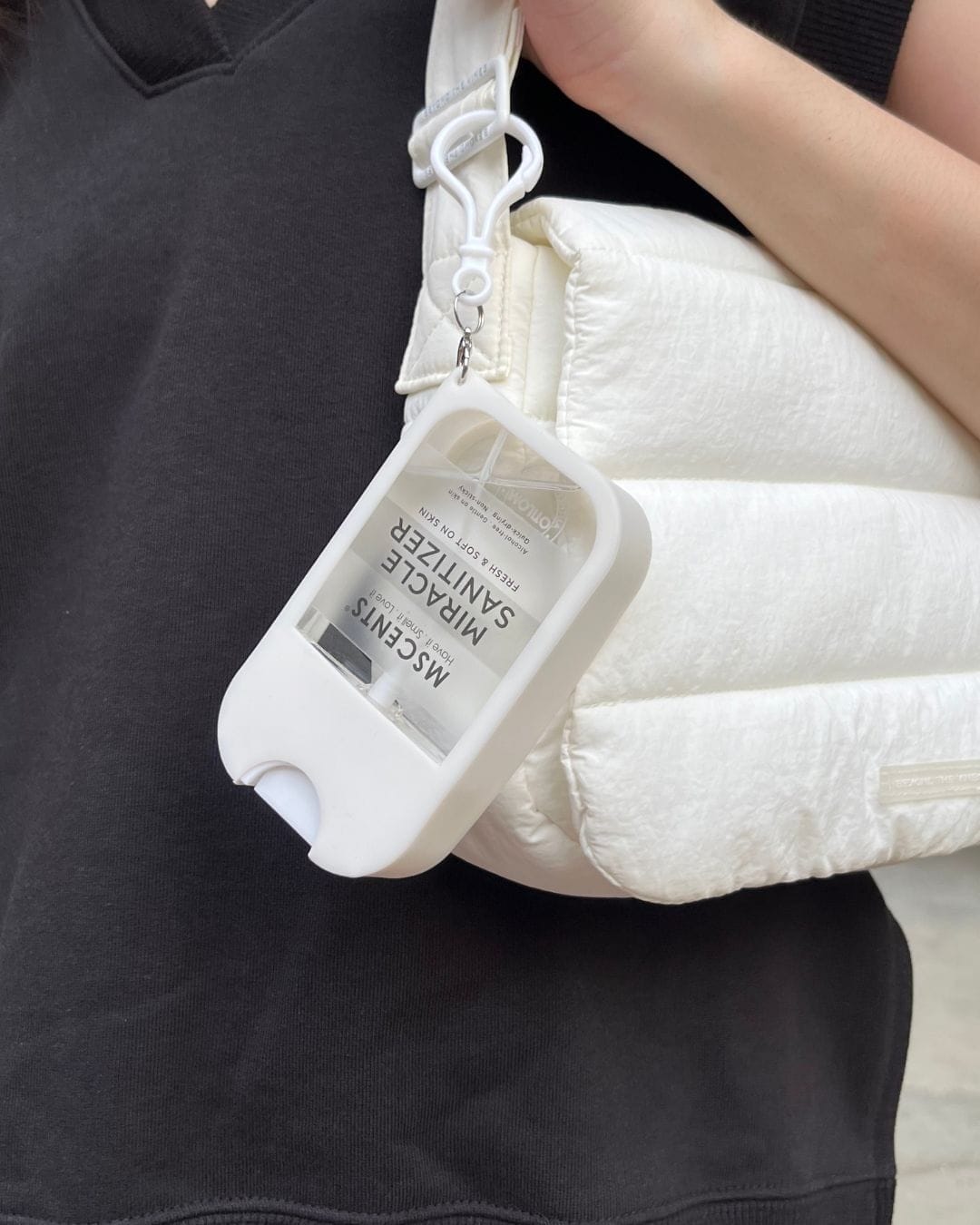 A mini hand sanitiser attached to a white bag