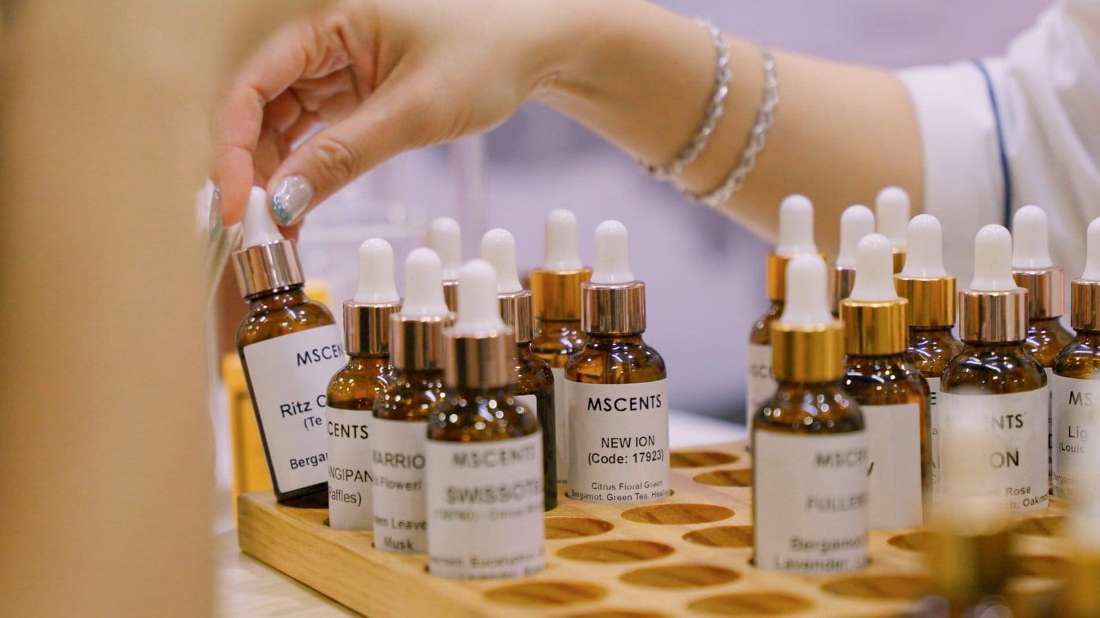 a-womans-hand-reaching-out-for-a-bottle-of-mscents-aroma-oil
