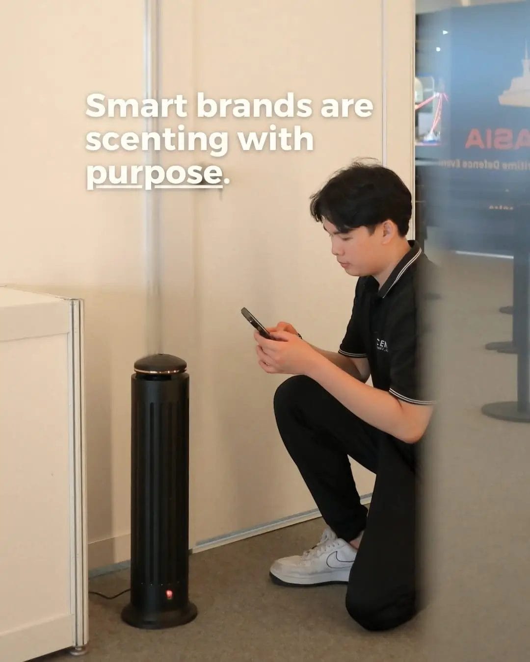 Male MScents staff sets up scent diffuser in a public space