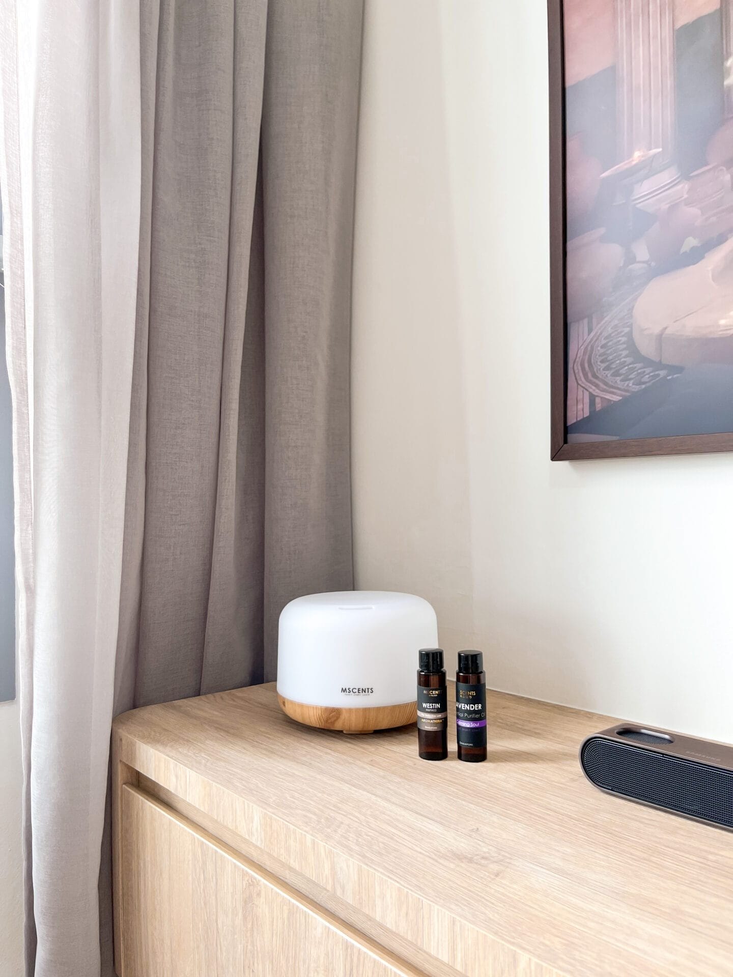 Two bottles of fragrance scent are right beside a diffuser on top of a table